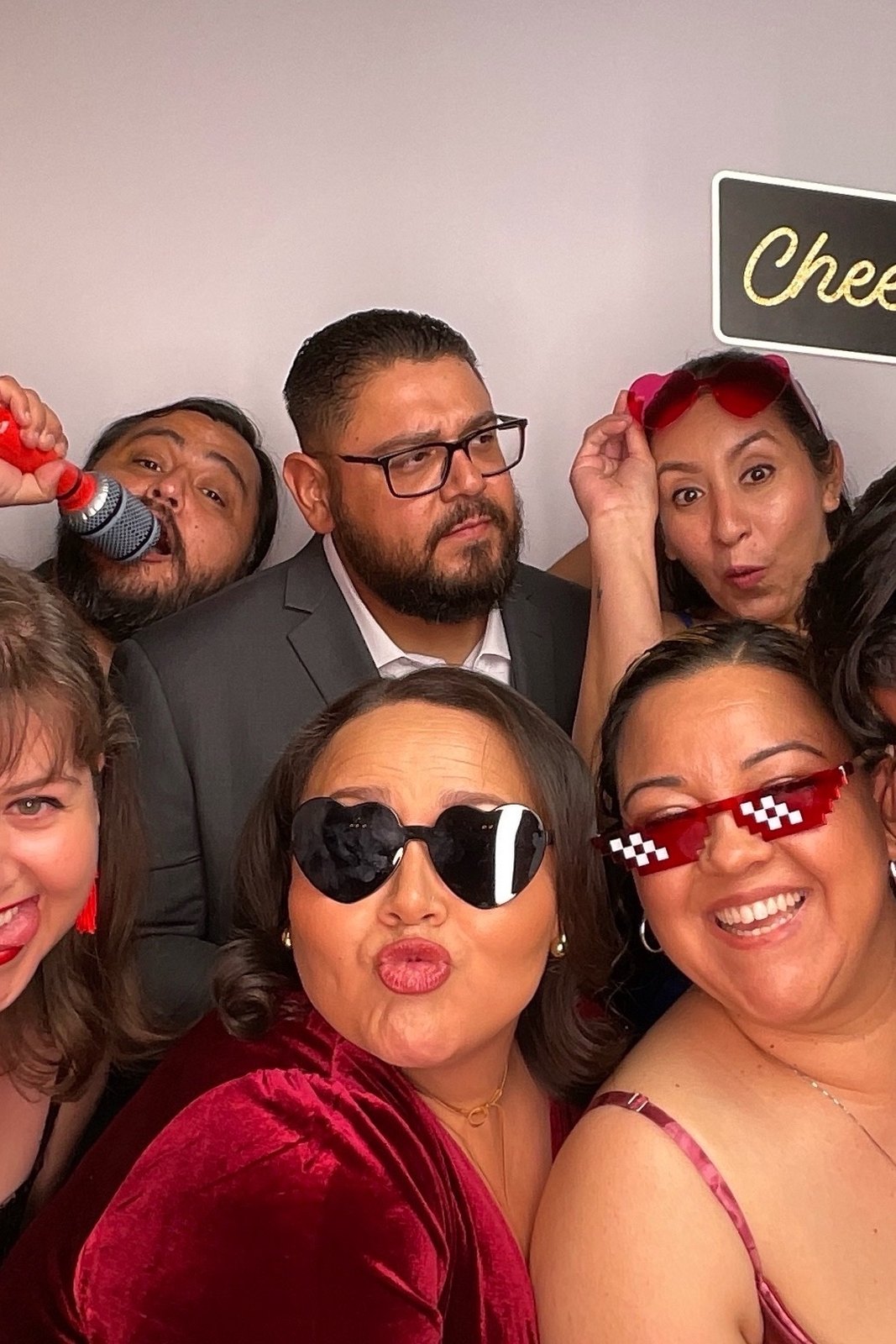 Wedding guests posing with props in the photo booth