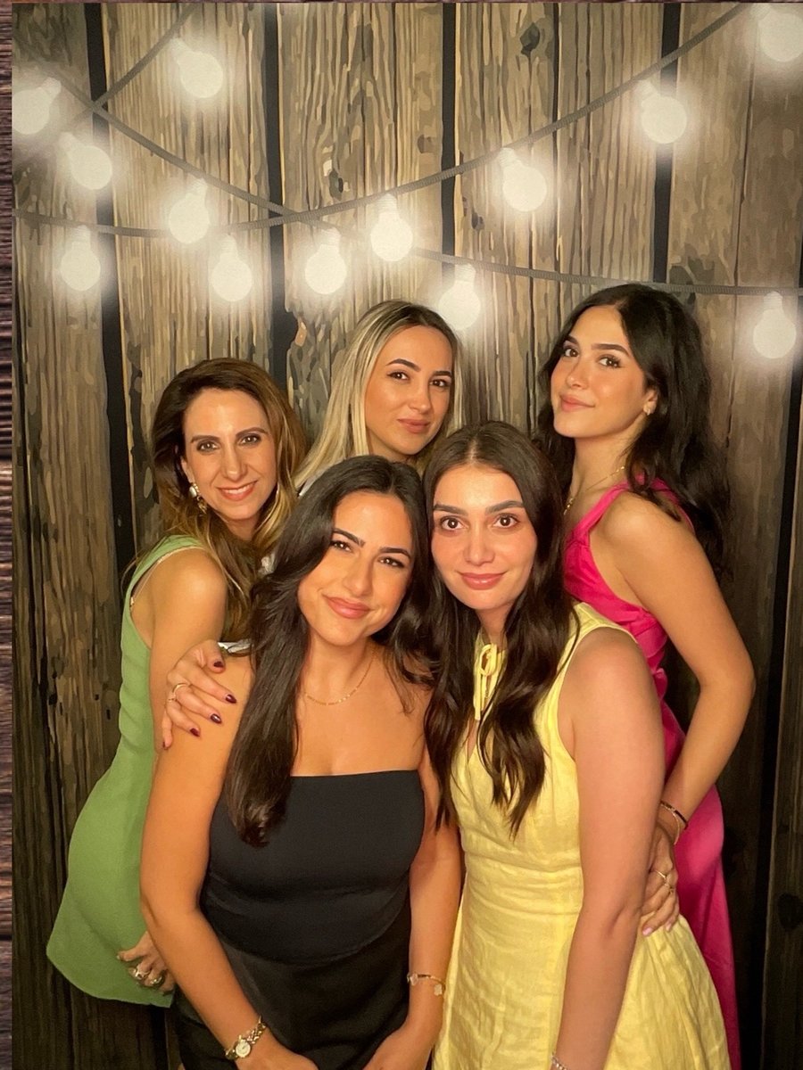 Birthday guests under string lights at the photo booth
