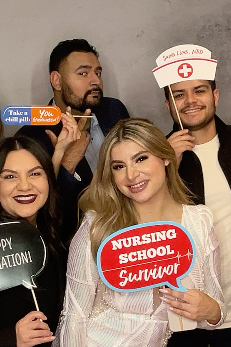 Graduates celebrating with themed props at the photo booth
