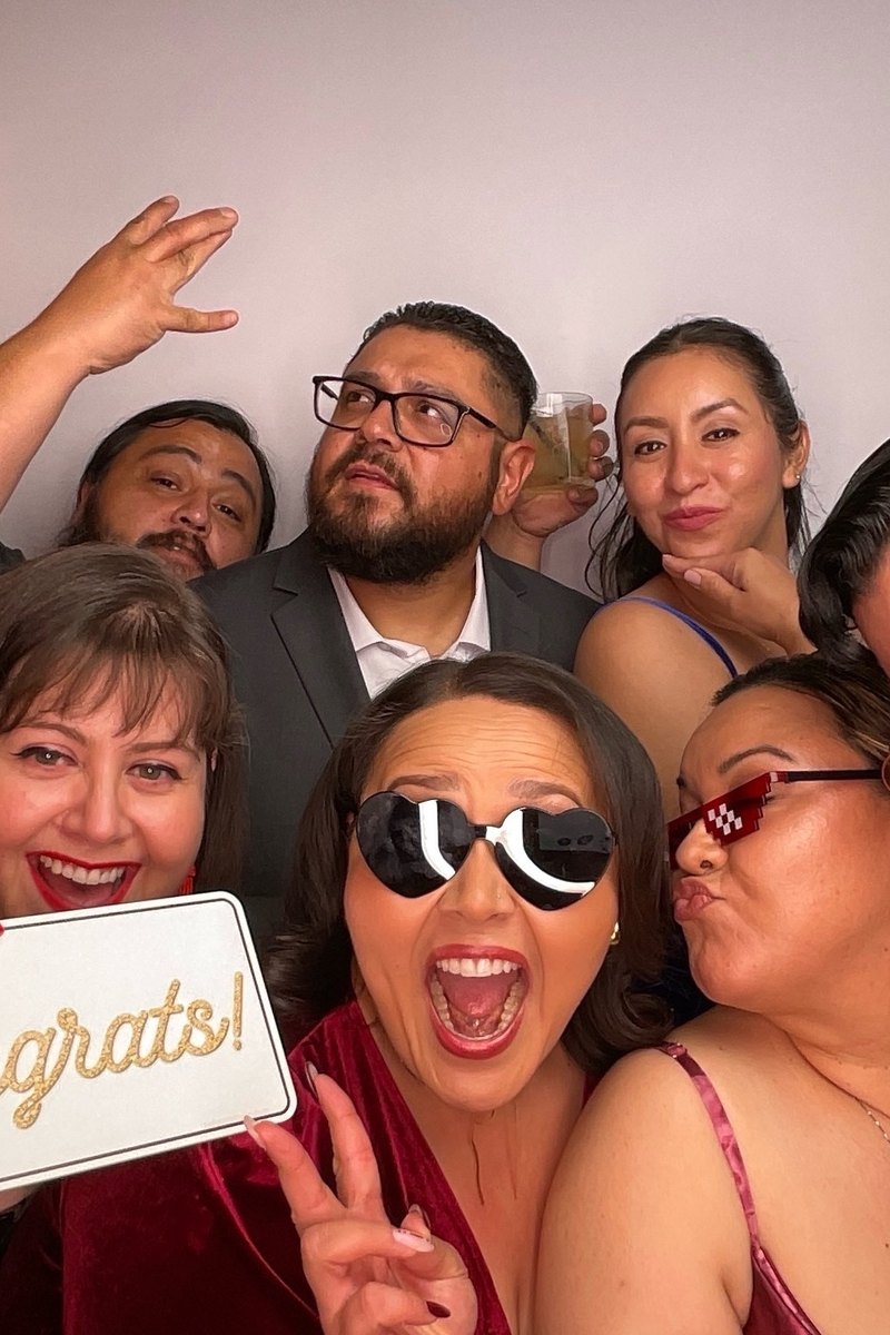 Wedding guests holding a Congrats sign in the photo booth