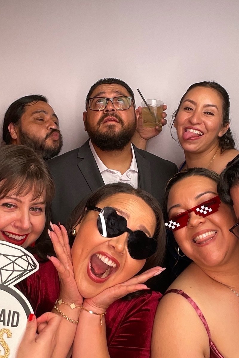Wedding guests laughing together in the photo booth